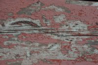 Paint peeling off a part of a picnic table.